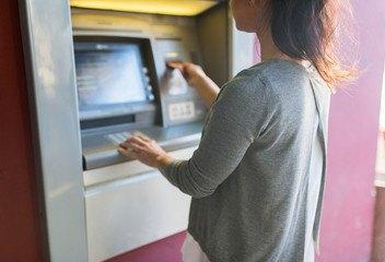 close up of woman inserting card to atm machine