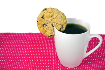 oatmeal raisin cookie on rim of white cup with black coffee
