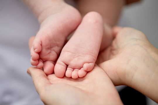 close up of newborn baby feet in mother hands