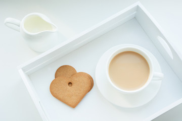 Winter concept. Breakfast. White mug of hot coffee with milk, cookies and milk jug in white birchbox. Top view.