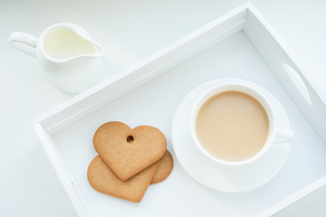 Winter concept. Breakfast. White mug of hot coffee with milk, cookies and milk jug in white birchbox. Top view.