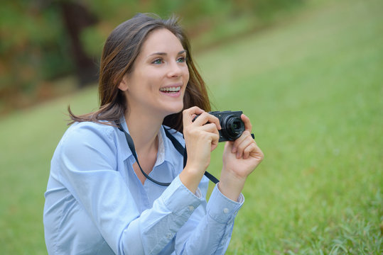 Woman in park taking photograph