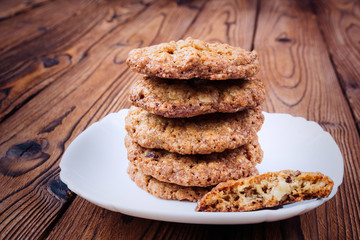 Oat cookies with raisins and nuts on a brown wooden table