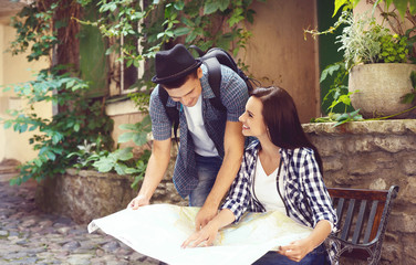 Couple of young travelers with a map on the street
