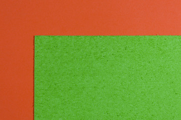 Fototapeta premium Eva foam ethylene vinyl acetate sponge plush apple green surface on orange smooth background