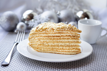 Piece of layer cake with custard and walnuts on a plate 
