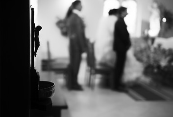 christian wedding couple at catholic church.Focus on Jesus statu