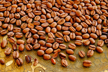 Brown coffee beans on an old plate.
