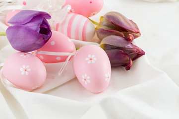 Obraz na płótnie Canvas Decorated easter eggs and purple tulips