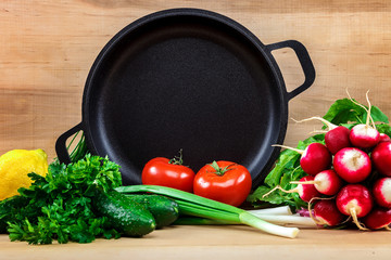 Fresh vegetables and pan on a wooden