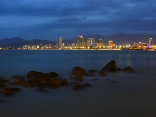 Fototapeta premium Nha Trang city skyline slow exposure over the bay just after sunset with the city lights ablaze.