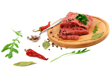 Meat on a cutting board and spices.