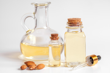 cosmetic almond oil in glass bottle on white background