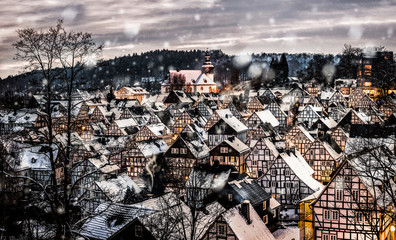 Bemused winter village in the early evening during Snowflakes are still covering the roofs in a nice white.