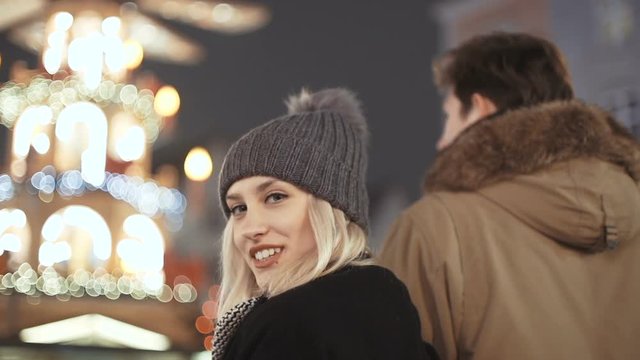 Young happy couple in love enjoying time over evening lights in a city.  Beautiful bokeh lights background.