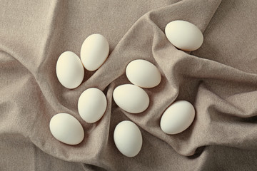 Fototapeta na wymiar Raw eggs on tablecloth, closeup