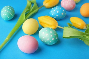 Colourful Easter eggs and flowers on blue background