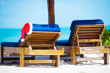 Santa Hat on beach lounger. Christmas vacation concept