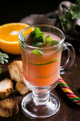 Festive Cranberry drink on Christmas background with fir branches and fresh berries, selective focus. Holiday concept. Dark stone table, Winter time