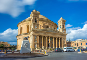 Fototapeta na wymiar Mosta, Malta - The Church of the Assumption of Our Lady, commonly known as the Rotunda of Mosta or Mosta Dome at daylight with moving clouds and blue sky
