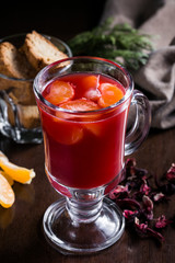 Festive Cranberry drink on Christmas background with fir branches and fresh berries, selective focus. Holiday concept. Dark stone table, Winter time