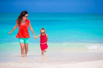 Naklejka premium Mother and little daughter enjoying time at tropical beach
