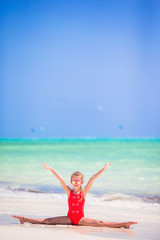 Fototapeta na wymiar Sporty little girl on white beach having fun