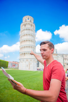 Young boy with toristic map on travel to Pisa. Tourist traveling visiting The Leaning Tower of Pisa.
