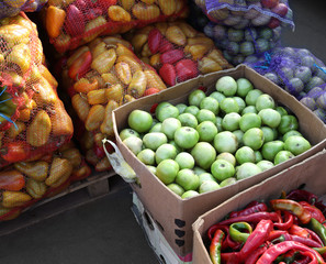 Fresh vegetables in cardboard boxes and mesh bags on market