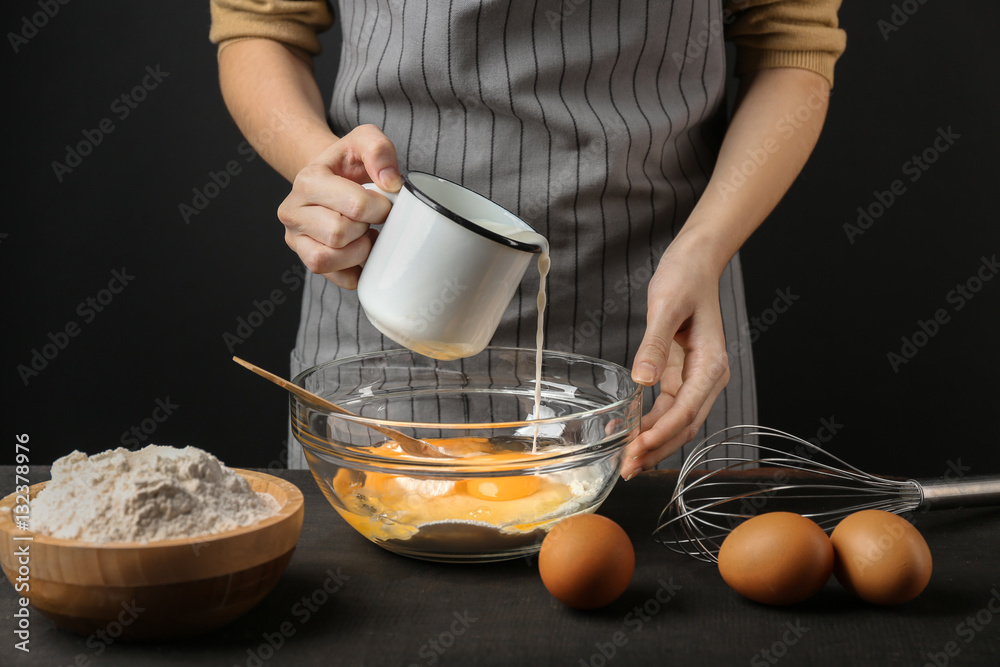 Poster woman making dough on kitchen table