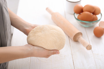 Woman holding raw dough, closeup