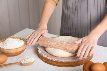 Obraz na płótnie Canvas Woman rolling out dough on kitchen table