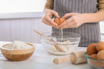 Woman making dough on kitchen table