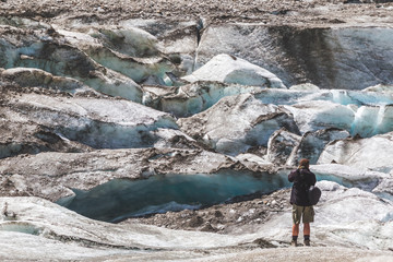 Man photographing glacier. Photographer in mountains