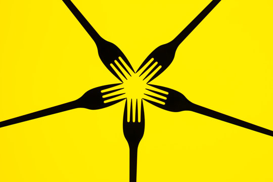 Silhouette of forks on yellow  background