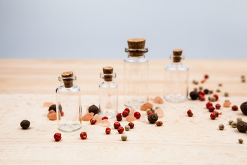 Spices and empty, small glass bottles with wooden texture
