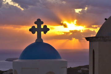 Blue domed Greek othodox church closeup with beautiful sunset. Santorini, Greece..