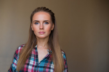 Fototapeta premium Beautiful woman's portrait on the neutral background. She has go