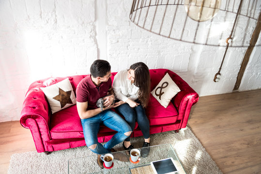 Happy Young Couple Relaxed Home With Bunny 
