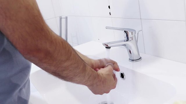 man wash his hands with water in the bathroom, care and body hygiene concept