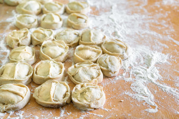 Preparation of manti (manty) on a kitchen wooden board. Traditional asian dumplings. 