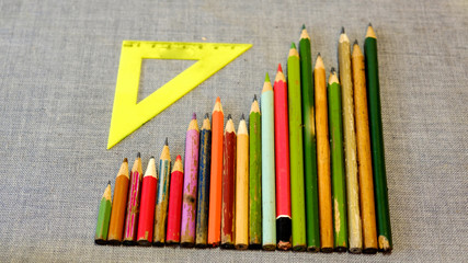 Wooden colored pencils and triangular ruler