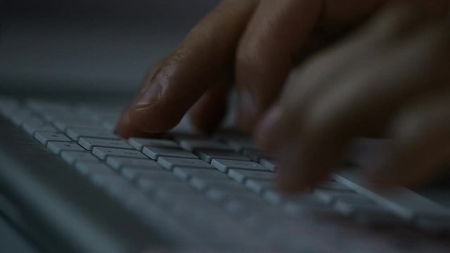 4K Hands typing on a keyboard at night