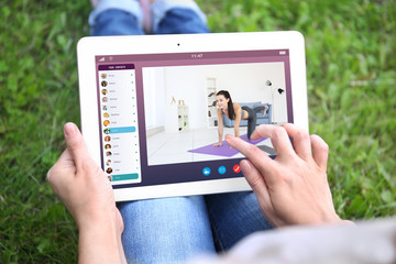 Woman watching sport training online on tablet. Fitness and sport blog.