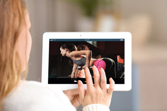 Woman watching sport training online on tablet. Fitness and sport blog.