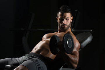 Young Man With Dumbbell Exercising Biceps