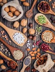 Various legumes and different kinds of nutshells in spoons. Waln