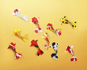 handmade paper craft origami koi carp fish on yellow background