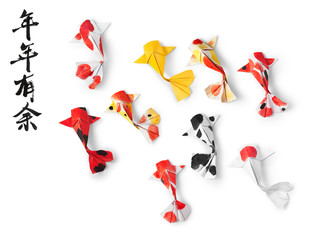 Handmade paper craft origami koi carp fish on white background. Translation of text: May you have a prosperous new year. 
