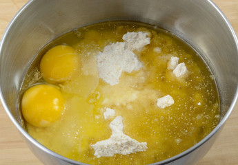 Stainless steel mixing bowl full cookie or cake mix, raw eggs and oil